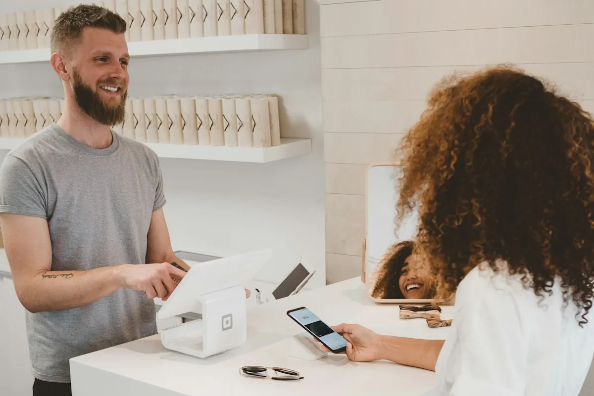 A customer paying with her phone at a small café counter